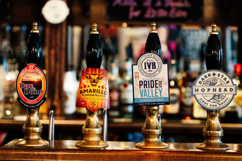 Four cask ale hand pumps on the bar at The Cricketers Arms