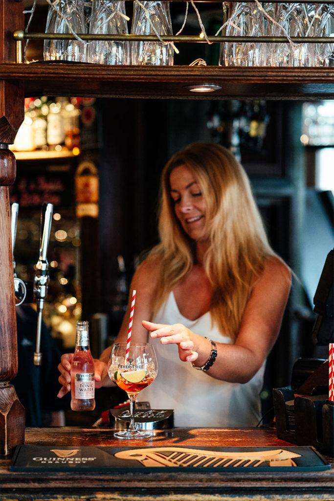 A member of the bar team preparing a drink at the bar