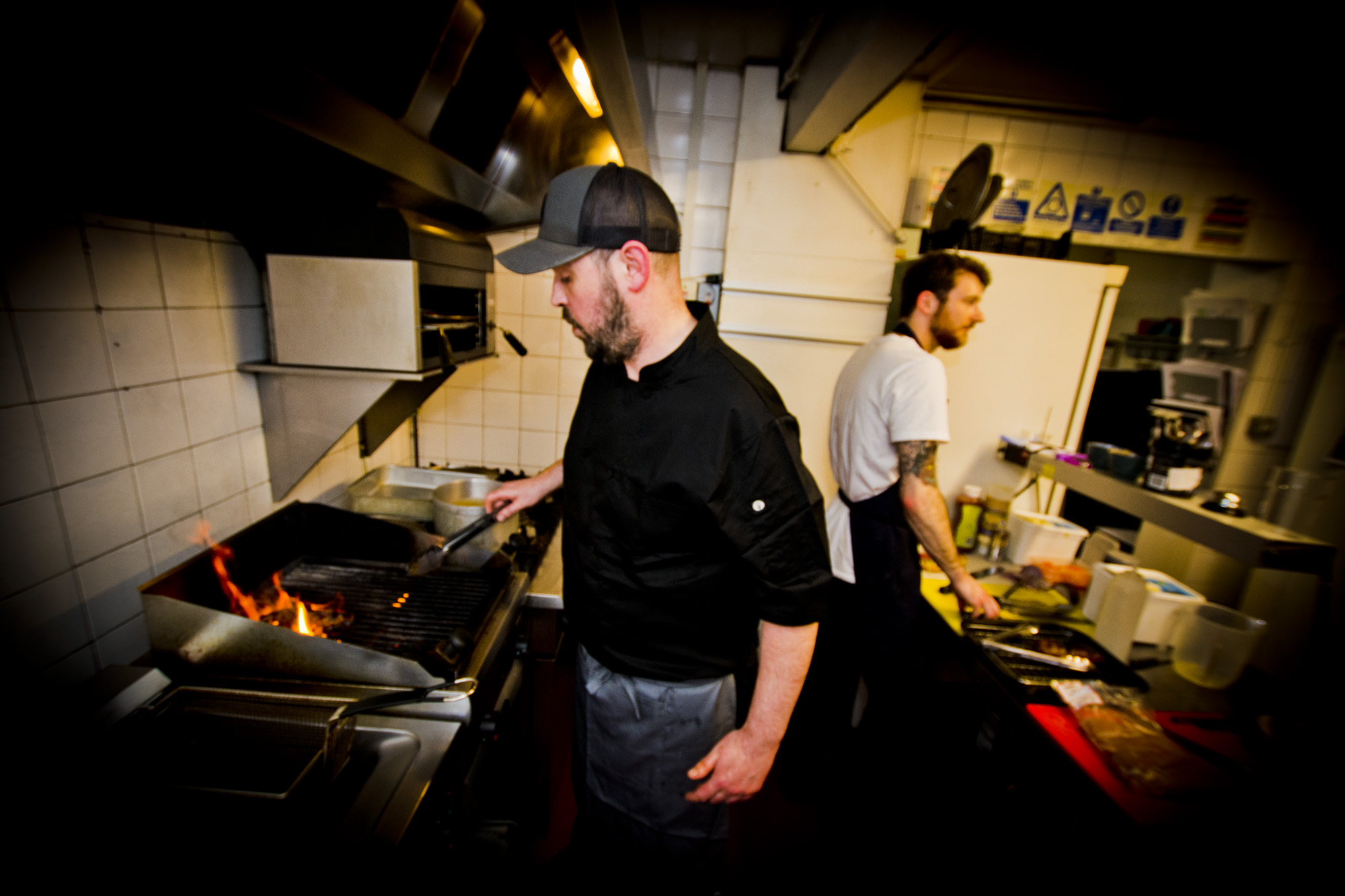 Two chefs working the grill in the kitchen at The Cricketers Arms