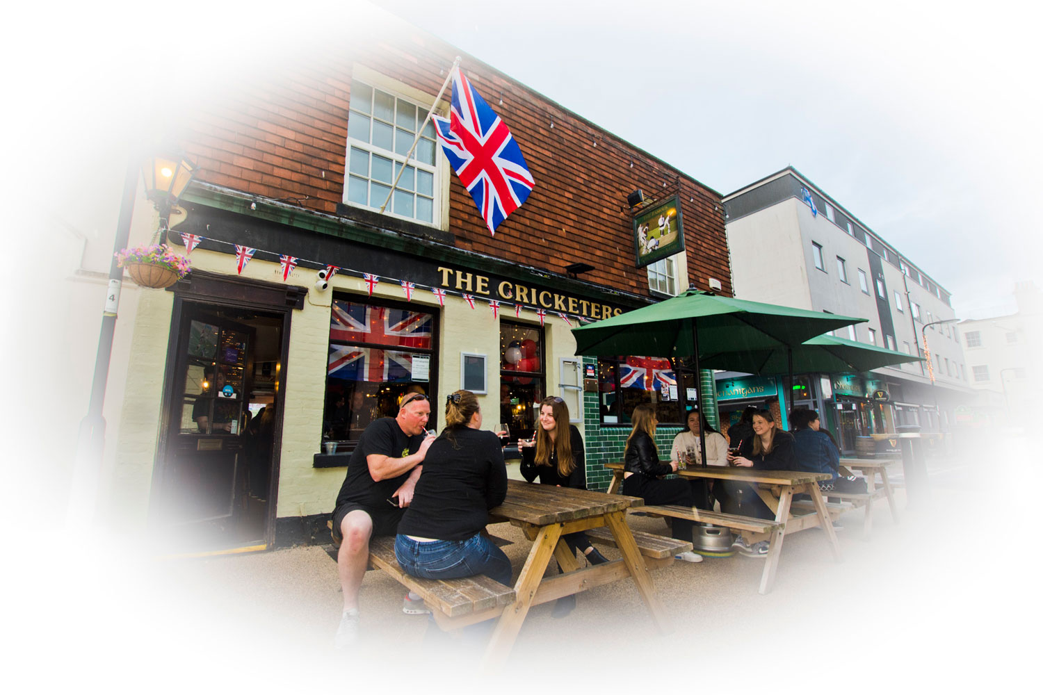 Customers at picnic benches outside the front of The Cricketers Arms